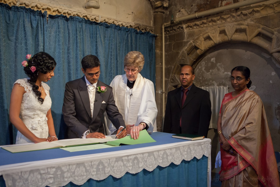 groom and bride signing the register at St Mary De Haura church